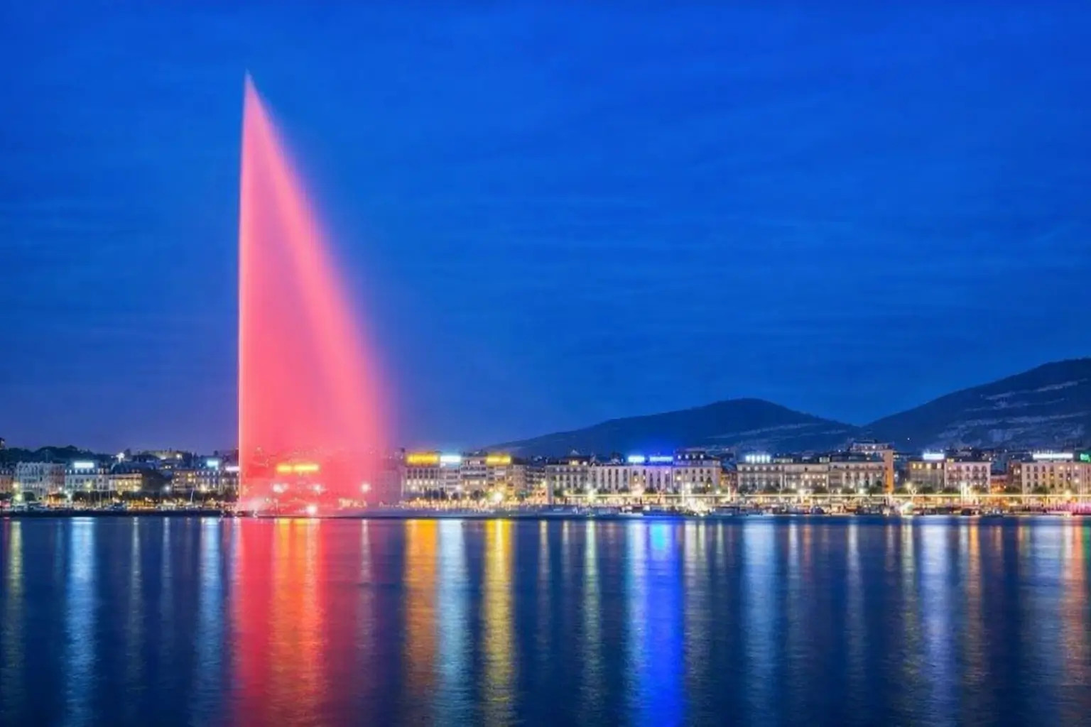 Imagen de Ginebra de noche con el Jet d’Eau, simbolizando apertura al mundo.