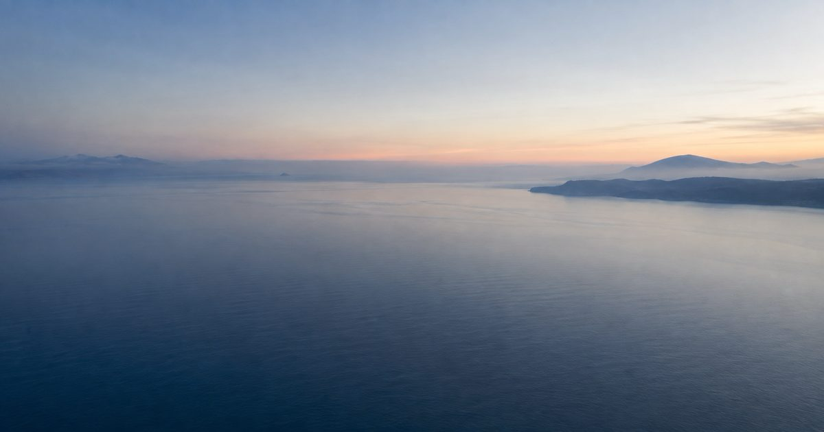 Vista aérea del estrecho al amanecer, dos orillas en la distancia